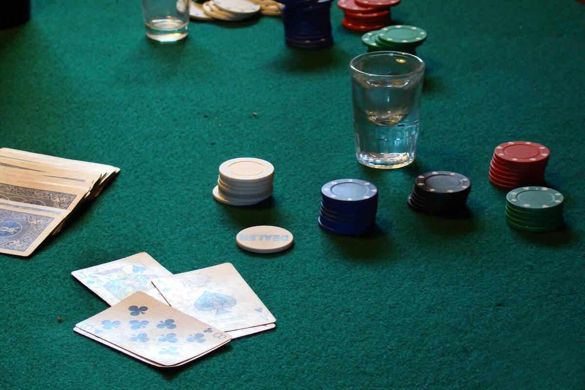 Clay poker chip set on a table next to a phone showing a digital chip stack in PartyPot
