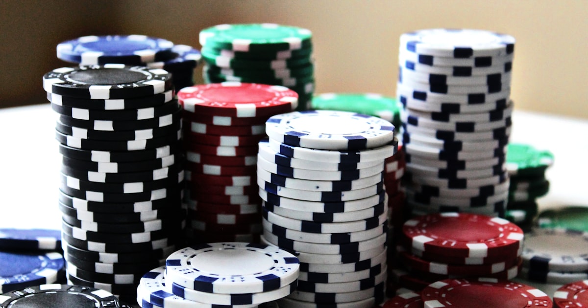 Poker chips stacked beside playing cards on a tournament table